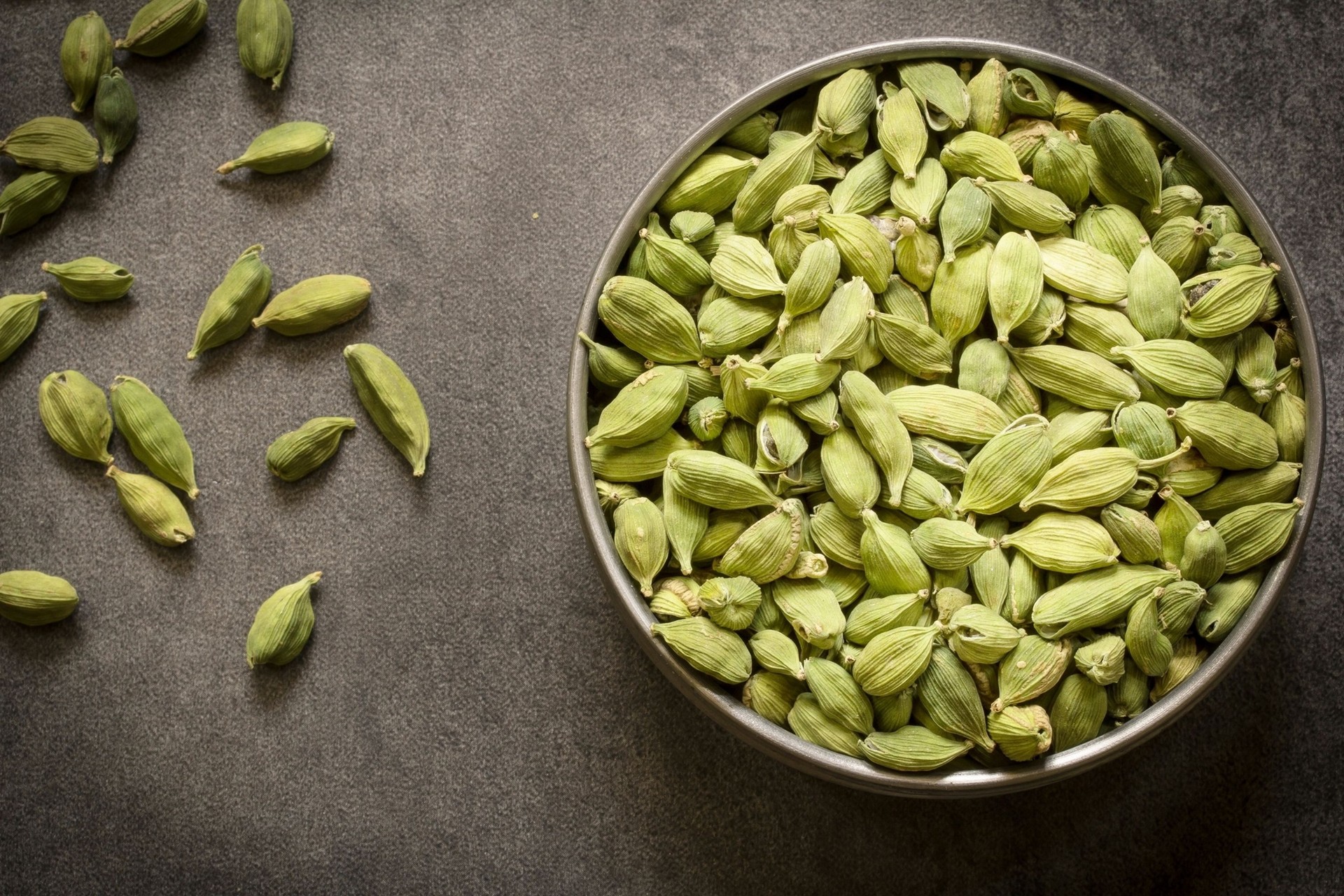 green cardamom pods in  steel bowl